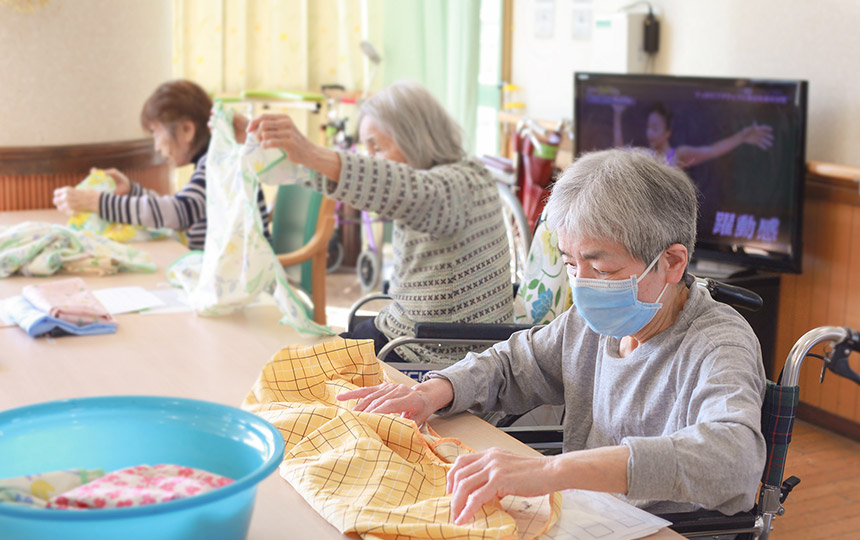 画像：見本を元に塗り絵を行う利用者